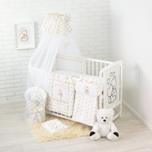 Baldachim do łóżeczka złoty w zestawie założony na krótszym boku.