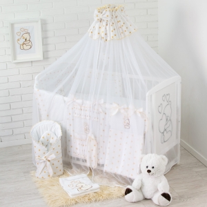 Złota moskitiera do łóżeczka zasłaniająca wnętrze łóżeczka.