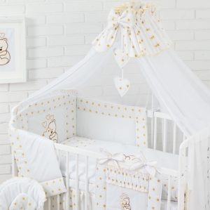 Złoty baldachim założony na dłuższym boku łóżeczka dziecięcego